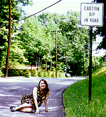 [Picture of me next to a 'DIP IN ROAD' sign.]